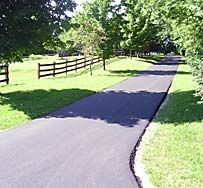 A Road Going Through A Grassy Field With A Fence In The Background | Manilla, IN | Floyd Crim & Sons Paving
