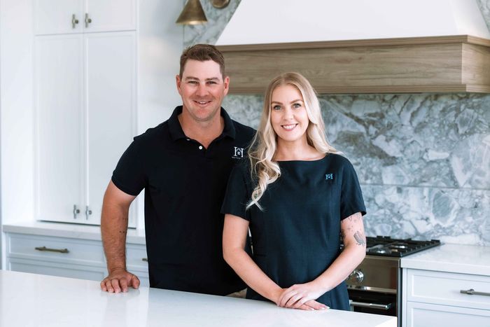 A man and a woman are standing in front of a truck.