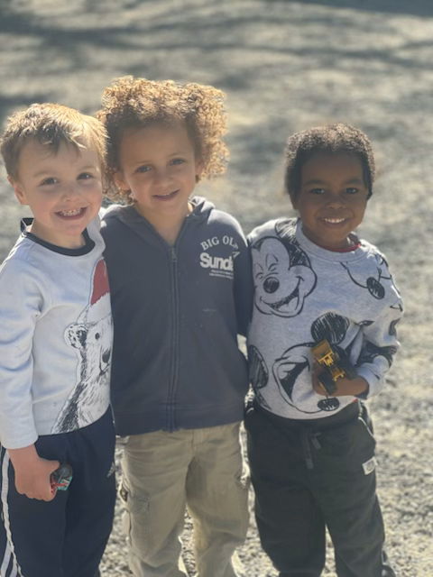 Three young children are posing for a picture together.