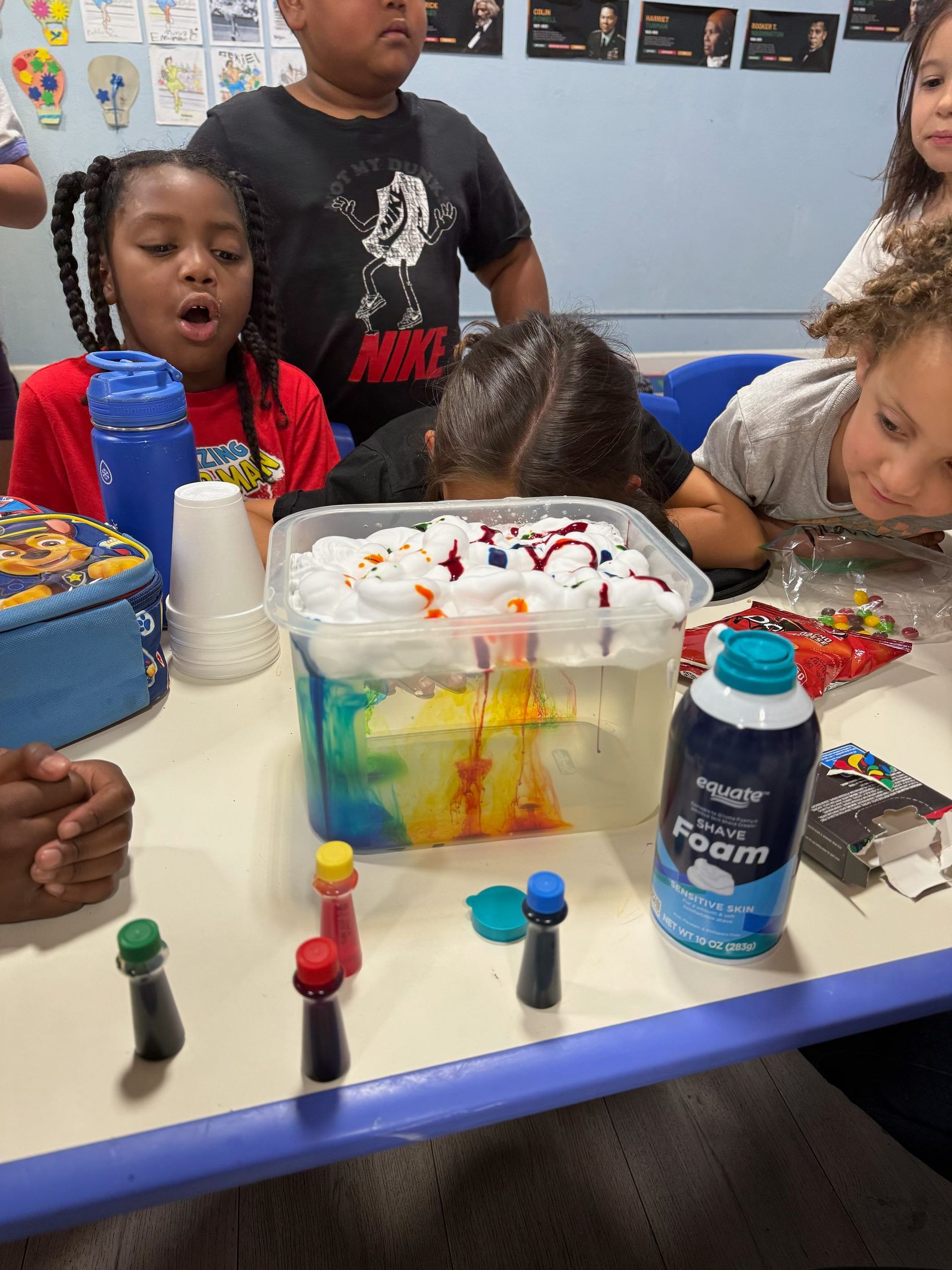 Two young girls are playing on a seesaw in a park.