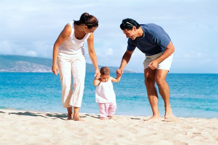 Parents playing with their Toddler on a Beach - foster care training process Cleveland, OH