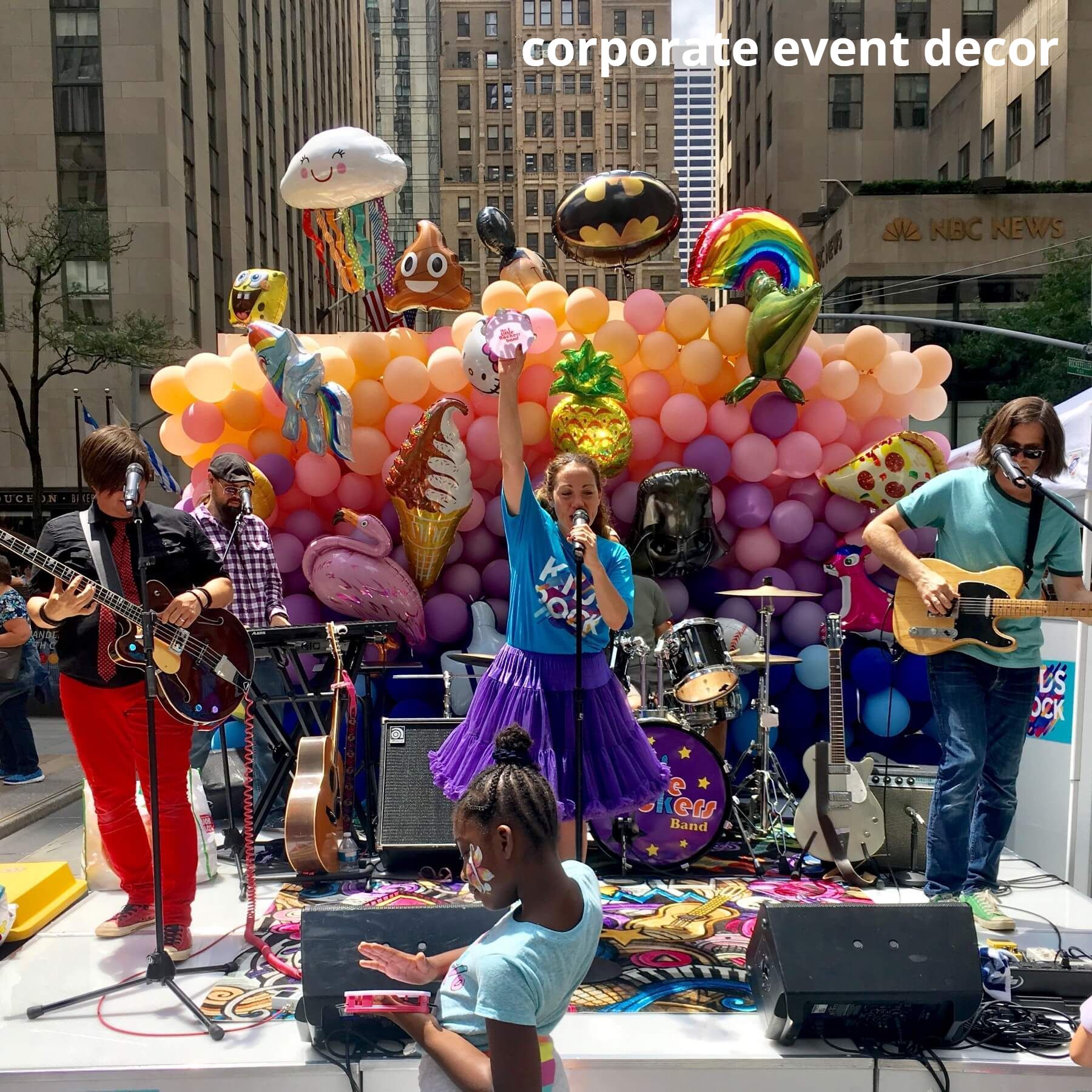 A group of people playing instruments in front of a corporate event decor