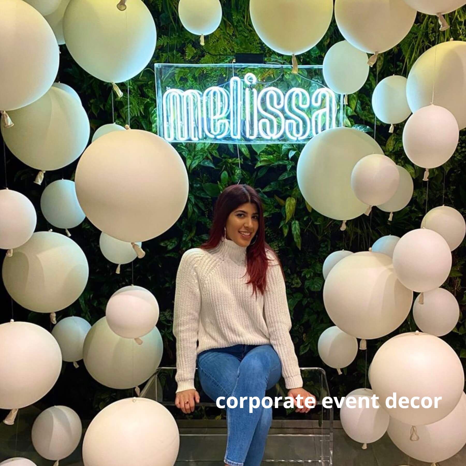 A woman is sitting in front of a sign that says melissa