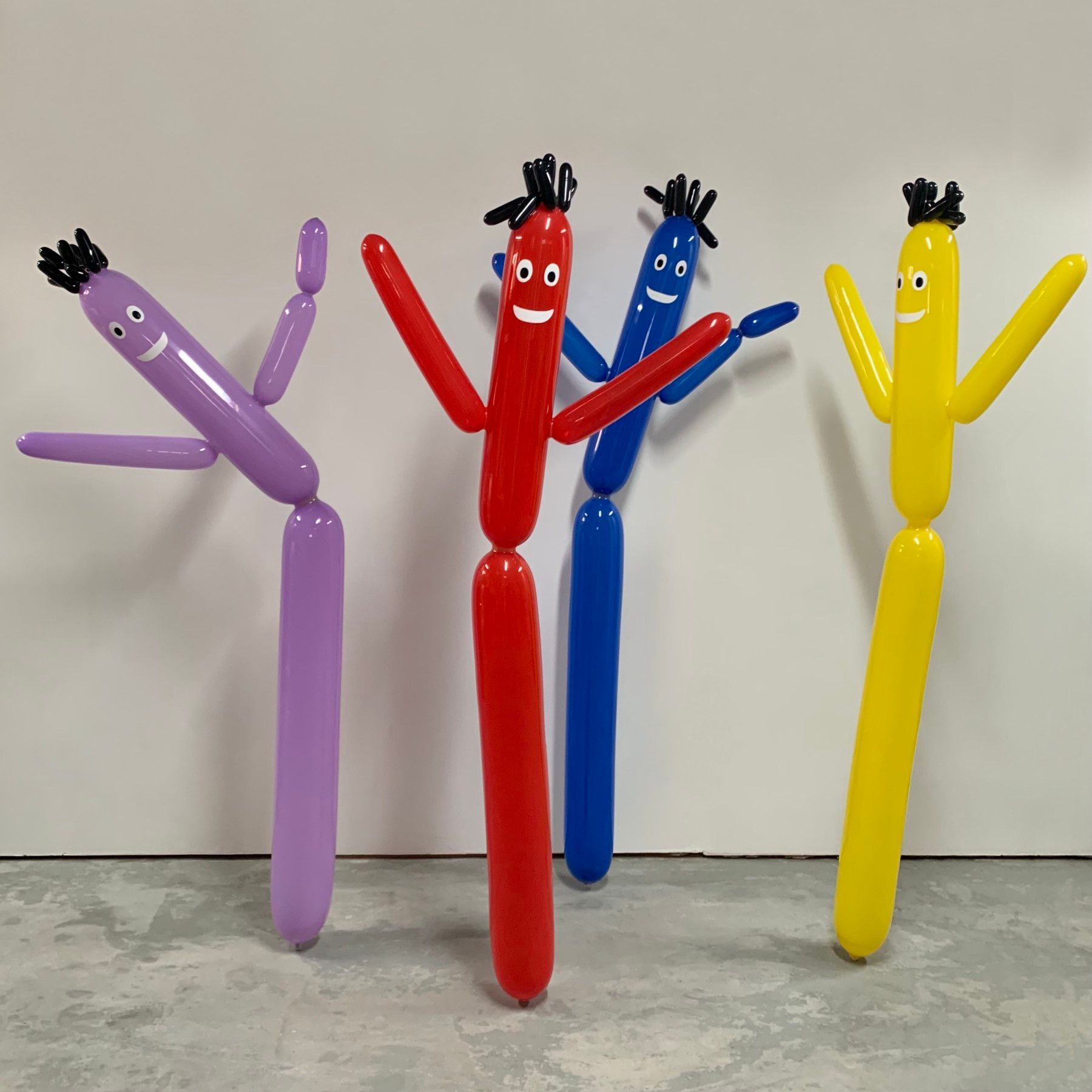 A group of balloons with faces on them are standing next to each other