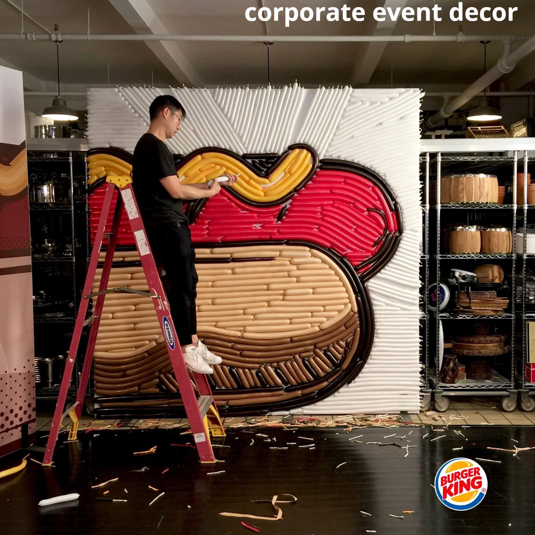 A man is standing on a ladder in front of a burger king sign