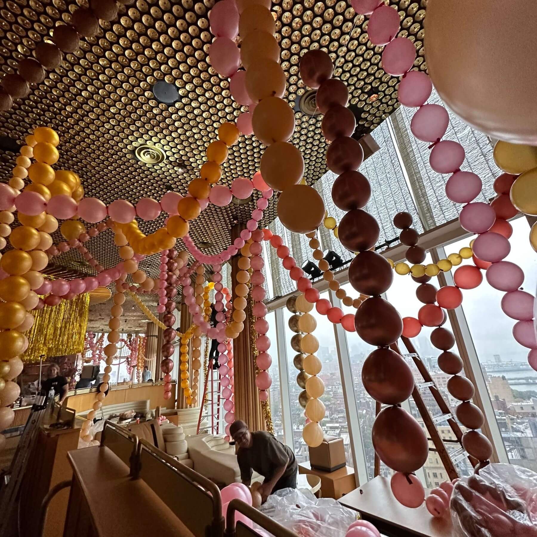 A room with balloons and beads hanging from the ceiling