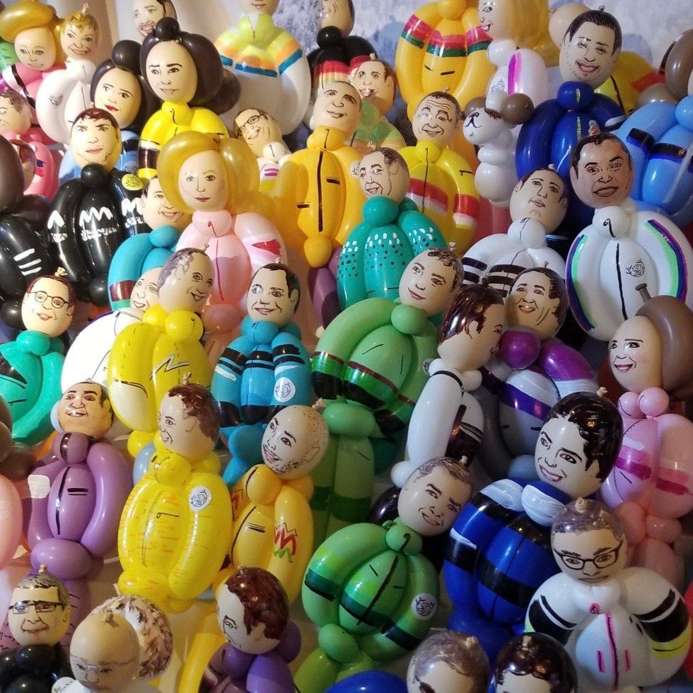 A bunch of colorful balloons with faces on them