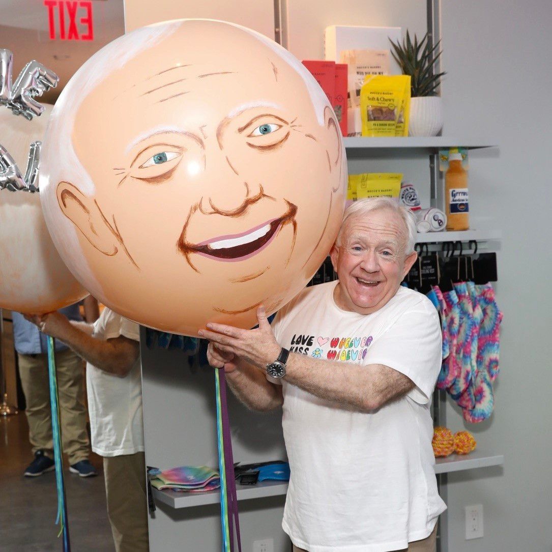 A man is holding a balloon with a man 's face on it