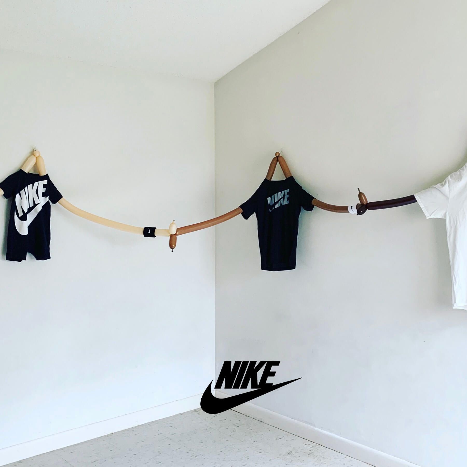 Two nike shirts are hanging on a clothes line