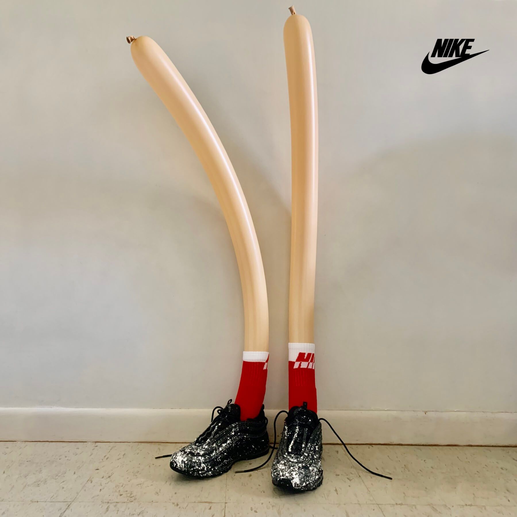 A pair of feet made out of balloons and nike shoes