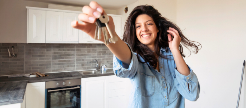 a woman is holding a bunch of keys in her hand in a kitchen