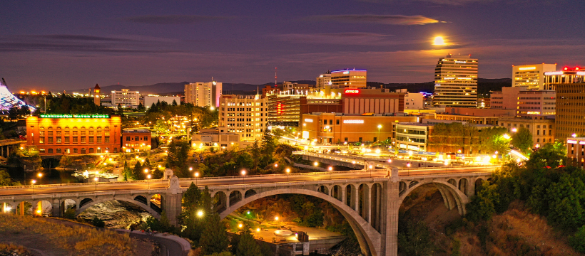 Spokane skyline at night with full moon and city lights