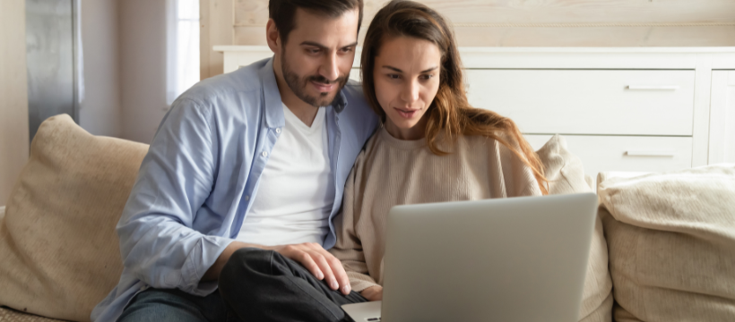 A couple researching home buying vs. renting on a laptop