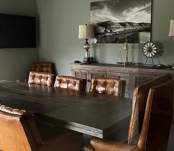 A dining room with a table and chairs and a picture on the wall