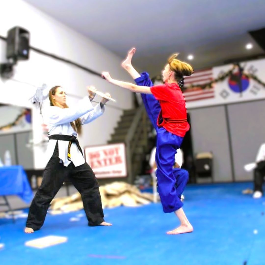 A group of men are practicing karate in a gym.