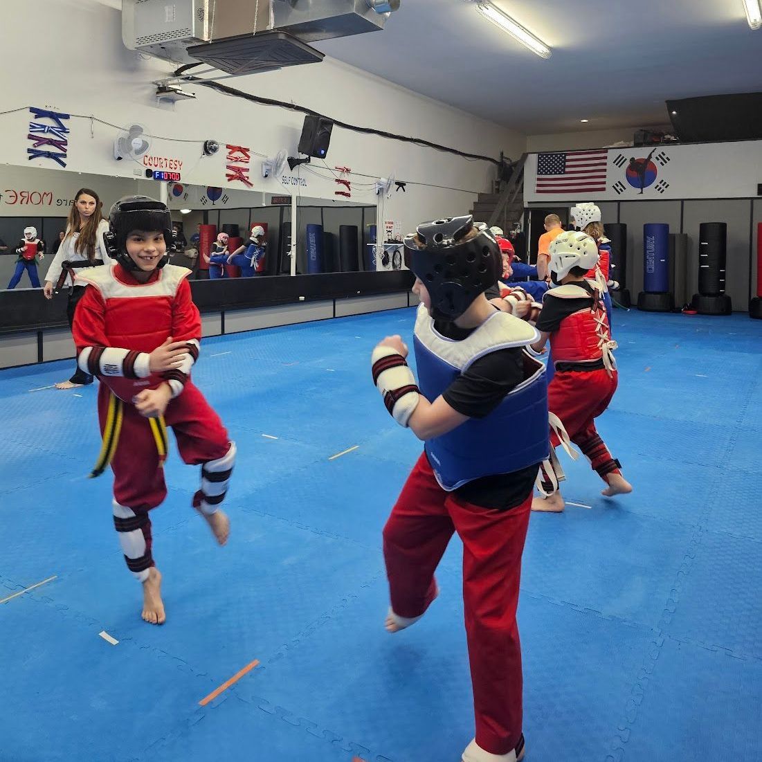 A boy and a girl are practicing taekwondo together.