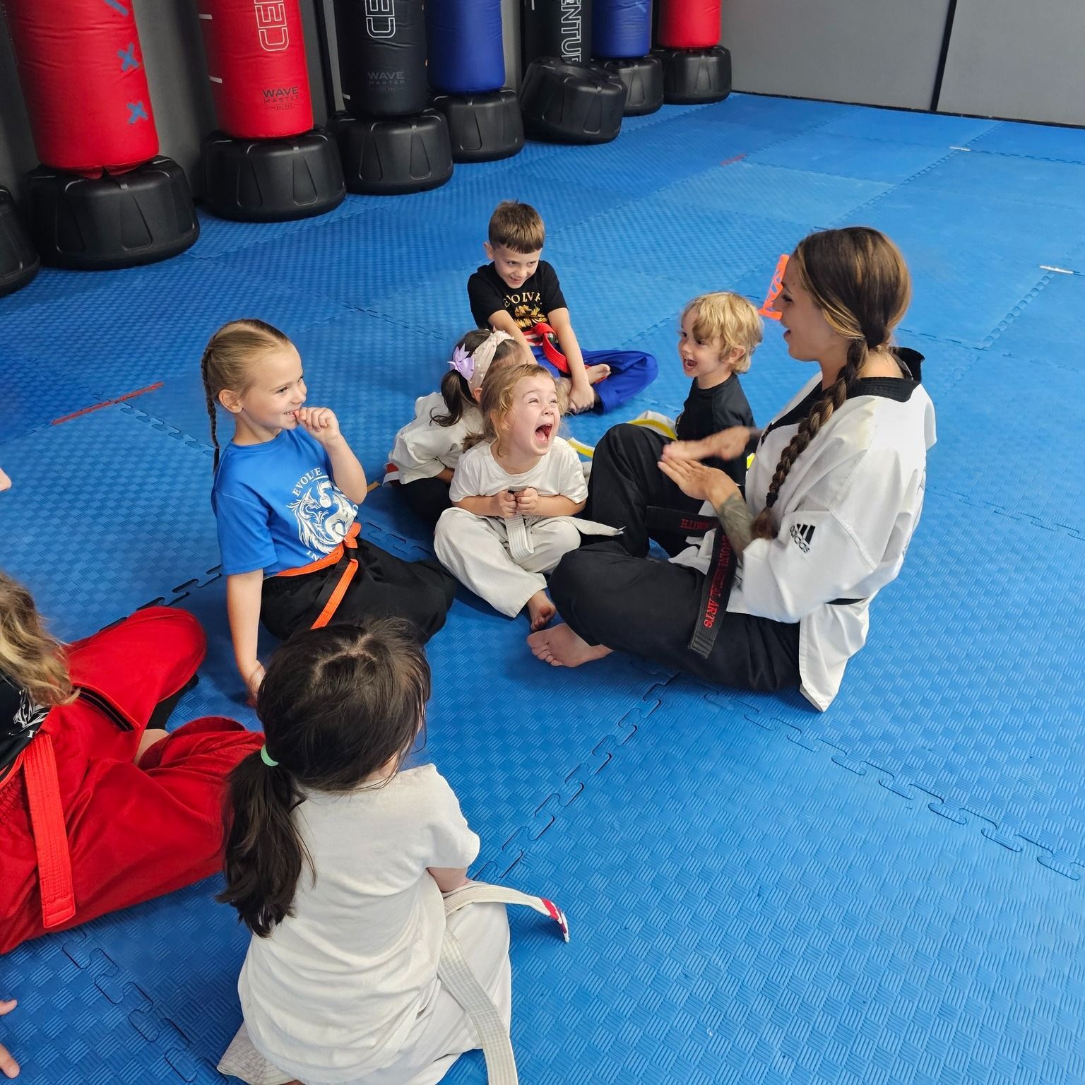 A group of young children in karate uniforms are posing for a picture.