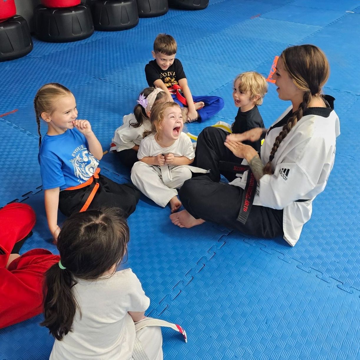 A group of young children in karate uniforms are posing for a picture.