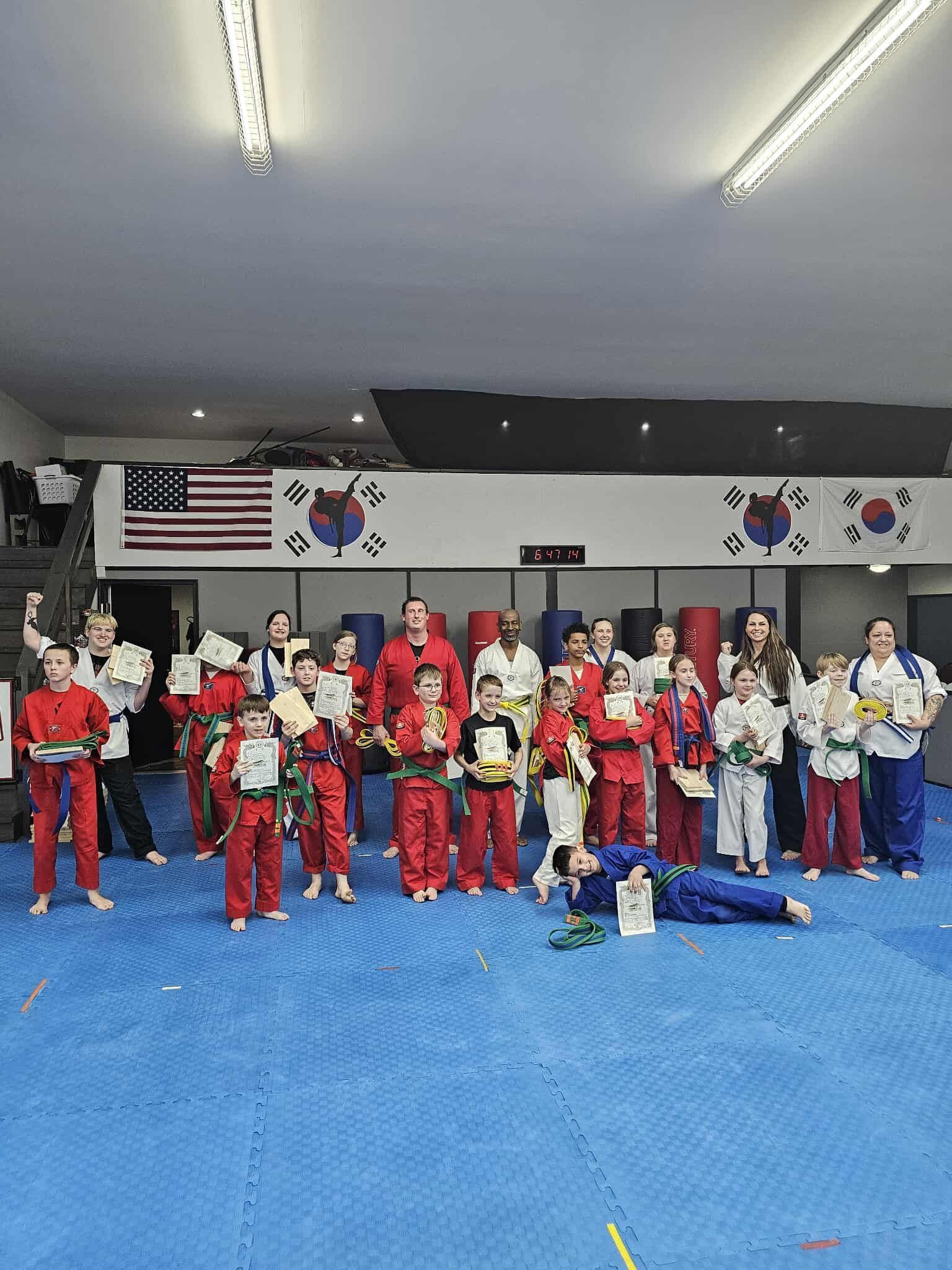 A man and a woman are practicing karate in a gym.