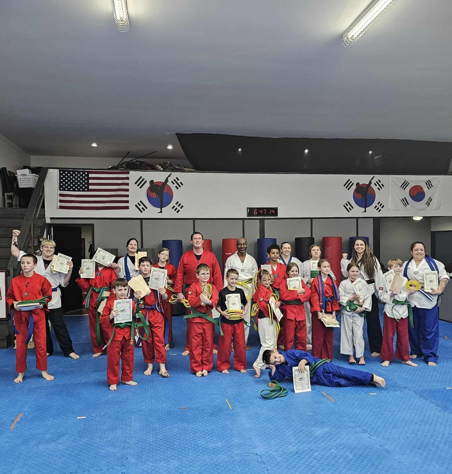 A man and a woman are practicing karate in a gym.