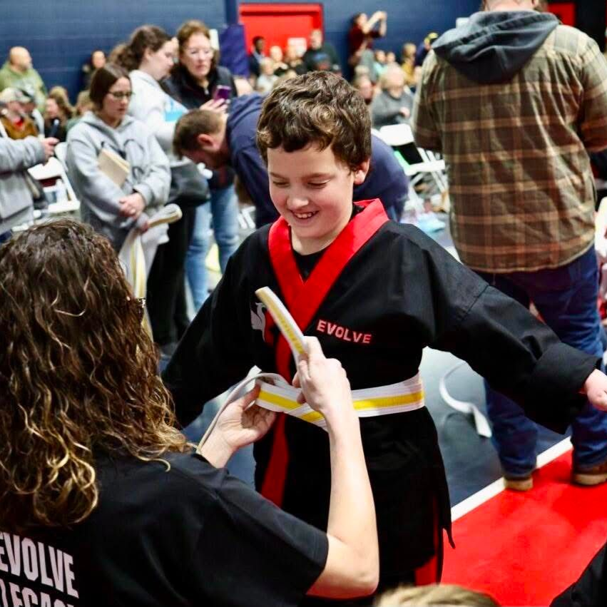 A young girl is practicing taekwondo in a gym.