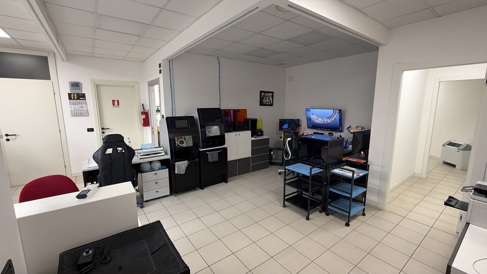 Vetrine e porta a vetri di una clinica dentistica illuminate di blu di notte, con l'insegna 