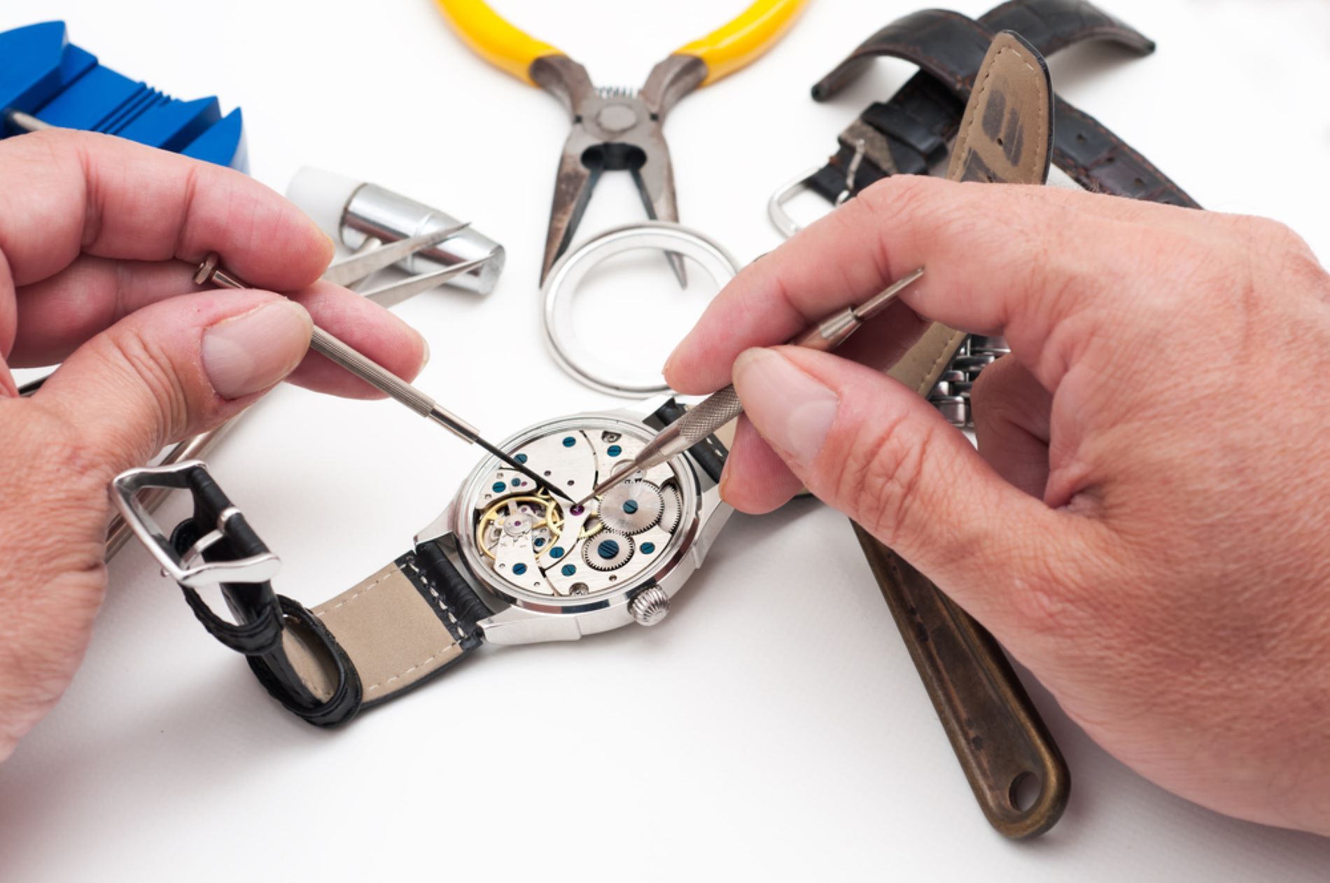 A Person is Fixing a Watch With a Pair of Pliers — Coastal Clocks & Watches in Buddina, QLD