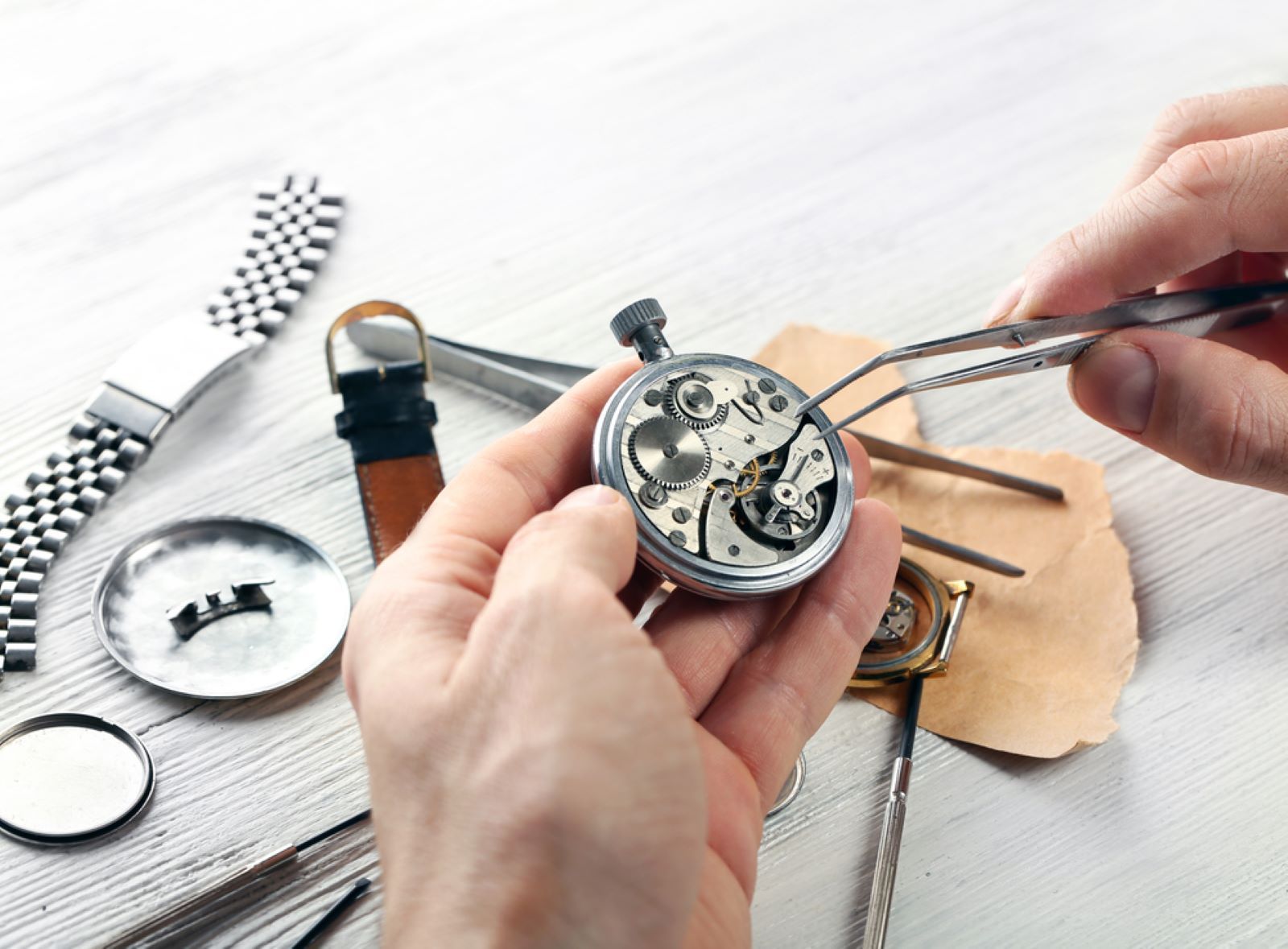 A Person is Fixing a Watch With a Pair of Tweezers — Coastal Clocks & Watches in Buddina, QLD