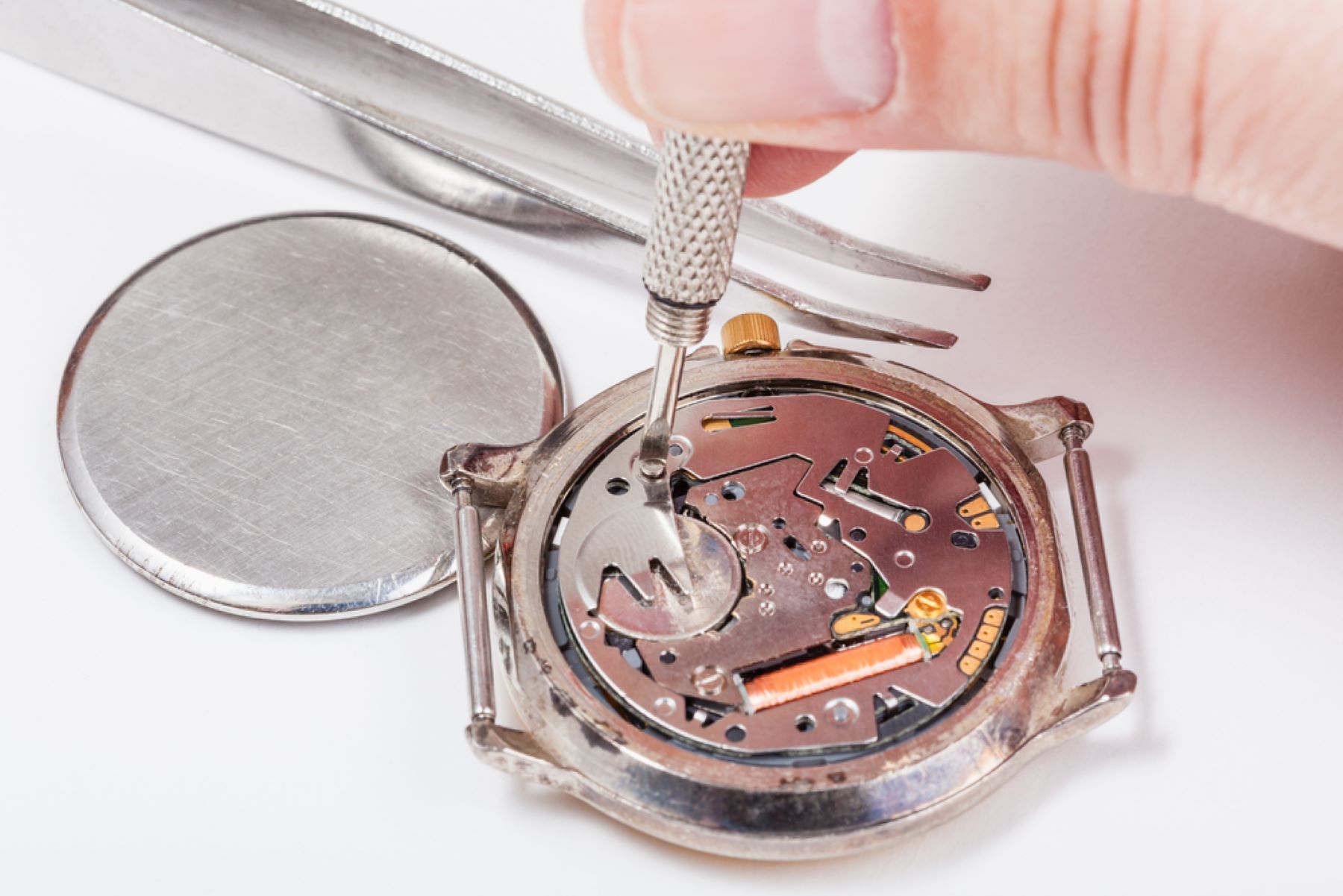 A Person is Fixing a Watch With Tweezers and a Screwdriver — Coastal Clocks & Watches in Buddina, QLD