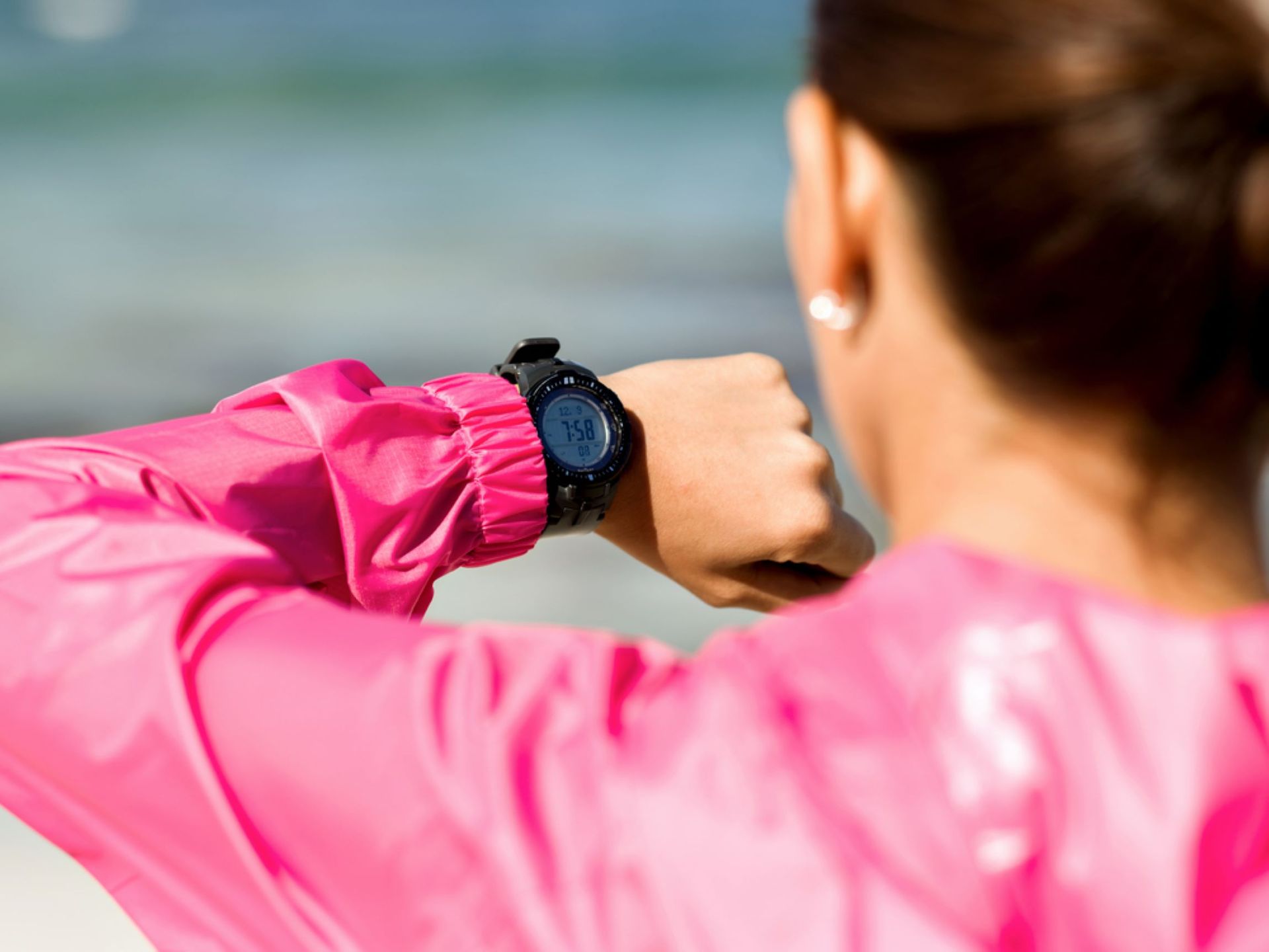 A Woman in a Pink Jacket is Looking at Her Watch — Coastal Clocks & Watches in Buddina, QLD