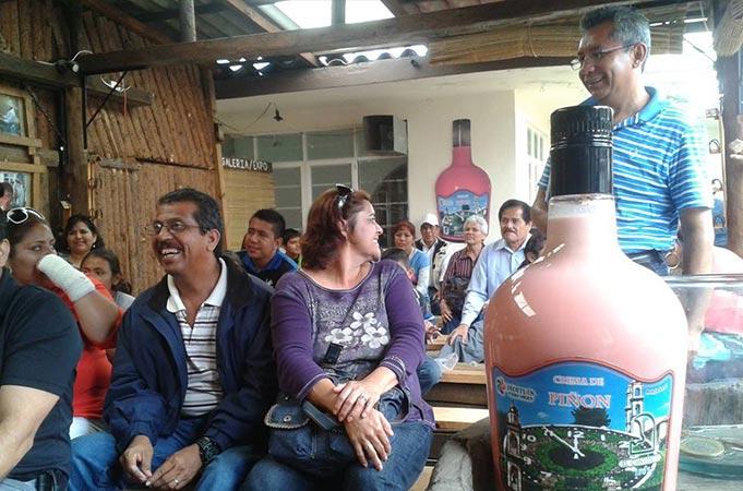 Un grupo de personas sentadas frente a una botella grande.