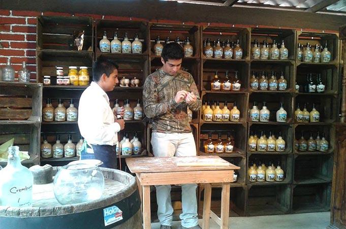 Dos hombres están parados frente a un estante lleno de botellas.