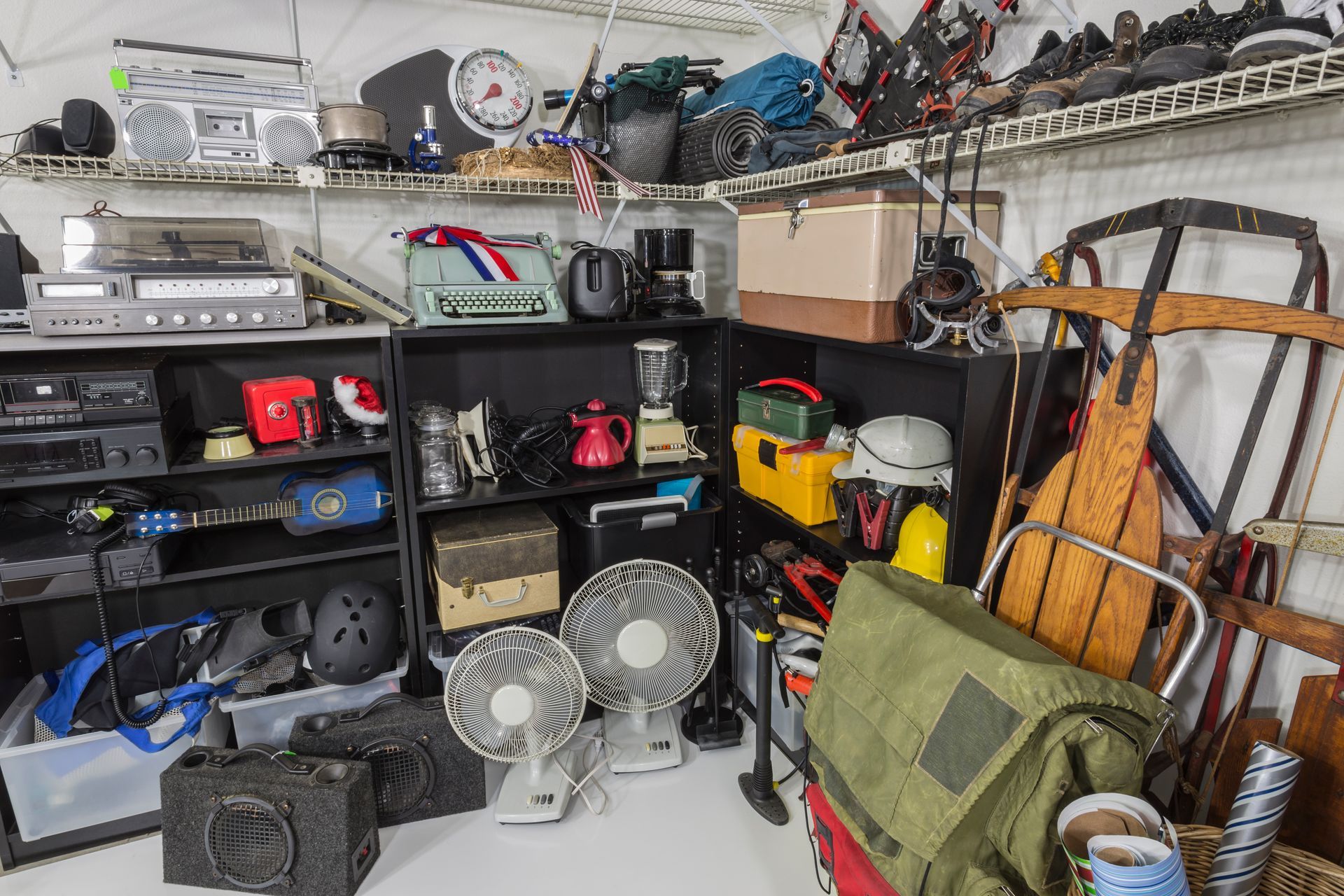 A garage filled with lots of junk and a green bag.