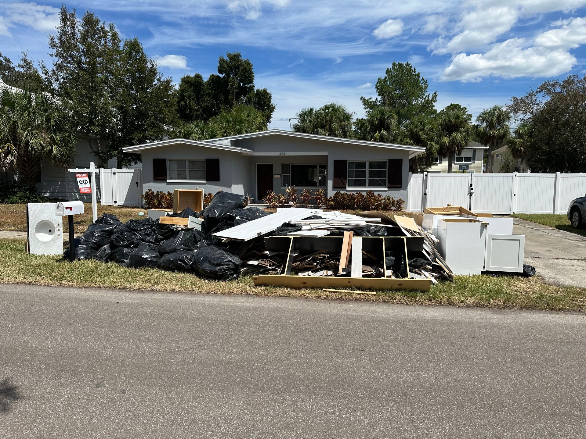 A pile of trash is sitting in front of a house.