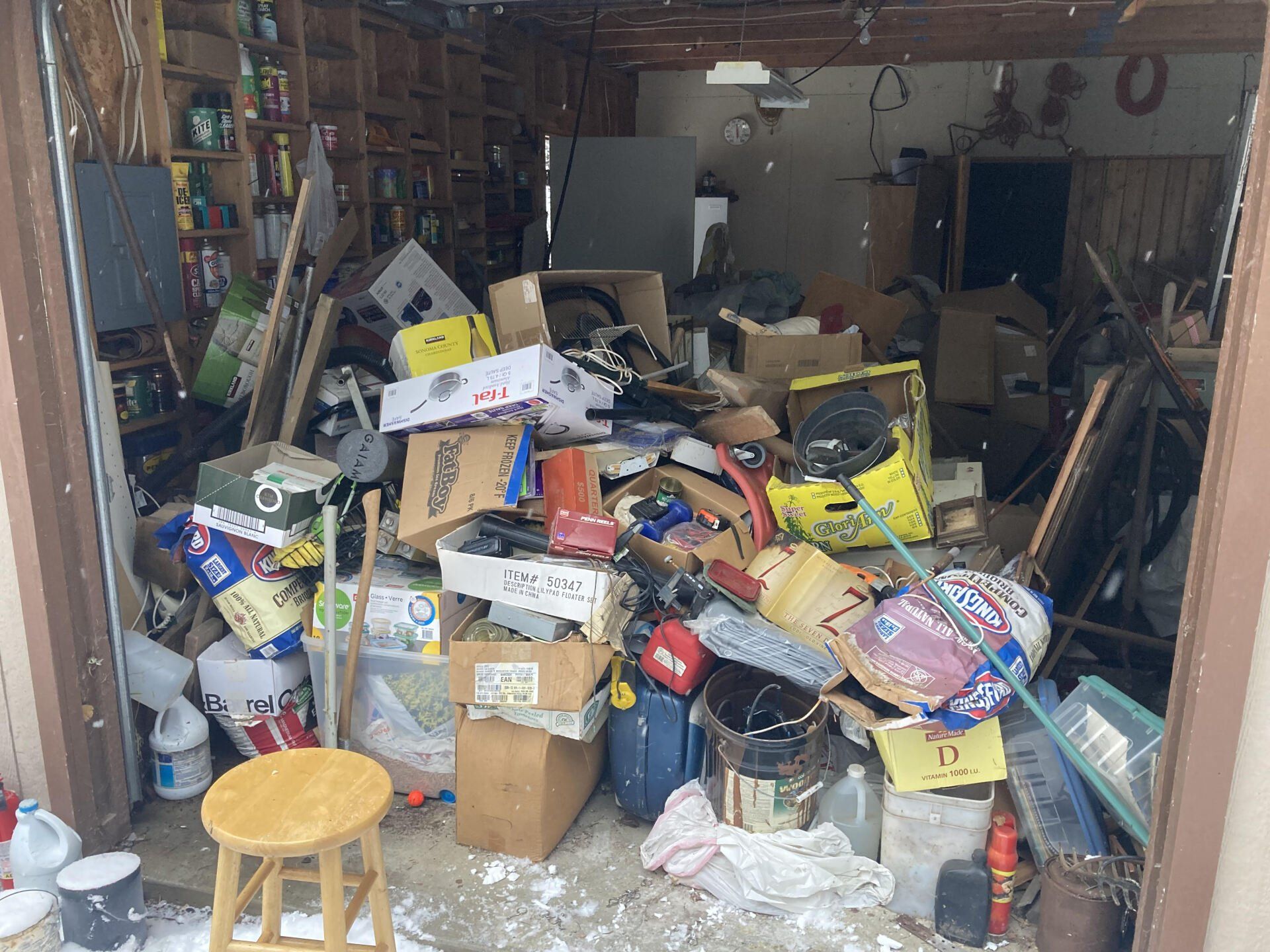 a garage filled with lots of junk and a stool .