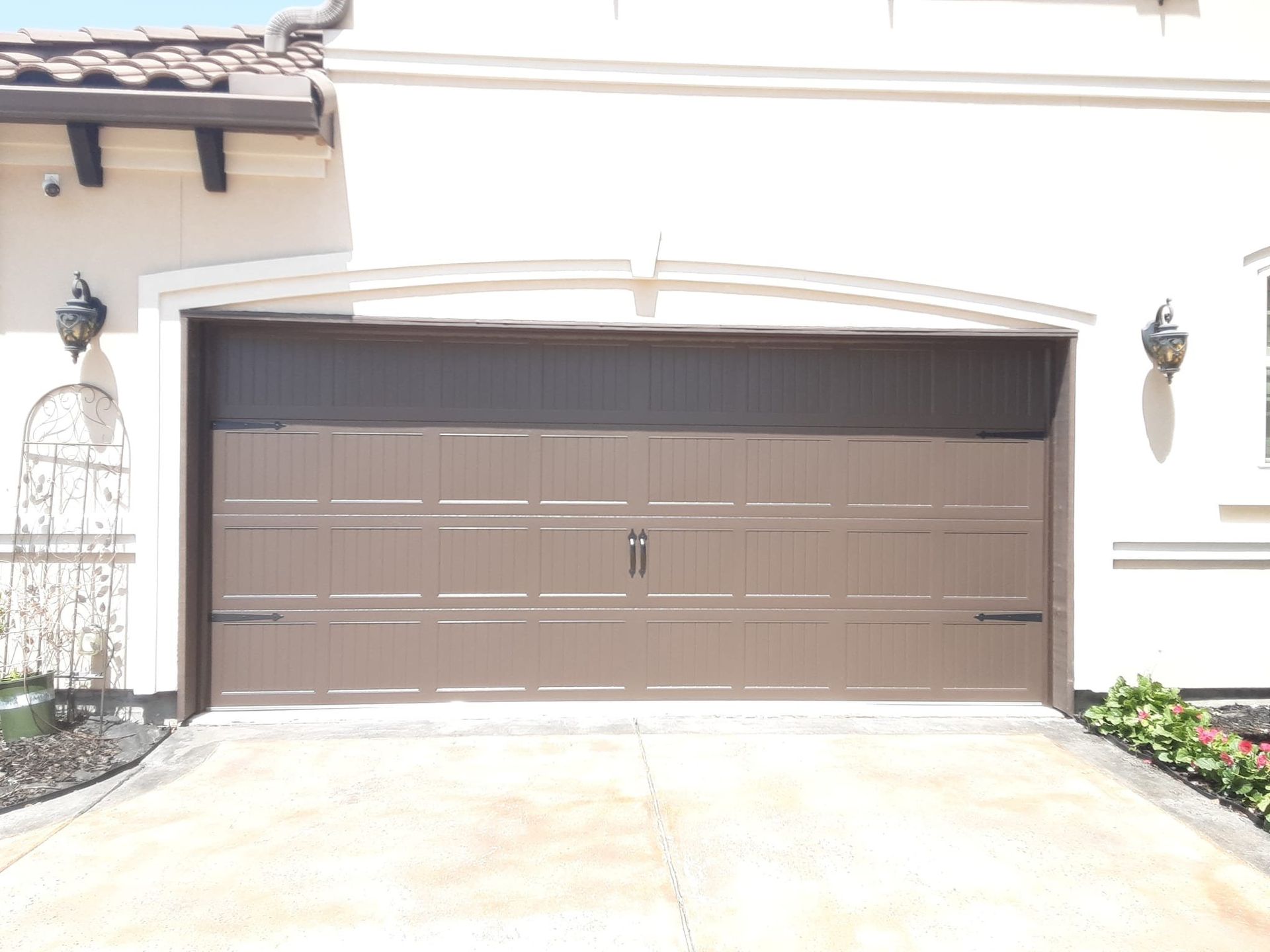 A white house with a brown garage door
