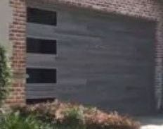 After Photo of A Brick House with Two Garage Doors.