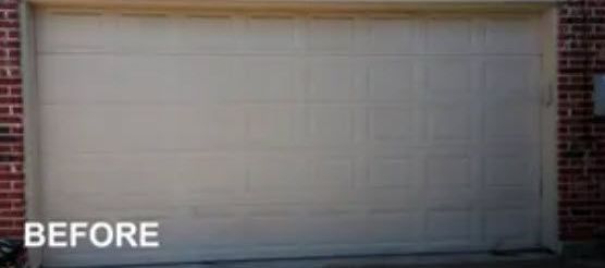 A Before Picture of A White Garage Door on A Brick Building.