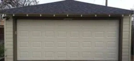 A Garage with A Roof and A White Garage Door.