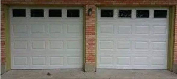 A Pair of White Garage Doors on A Brick Building