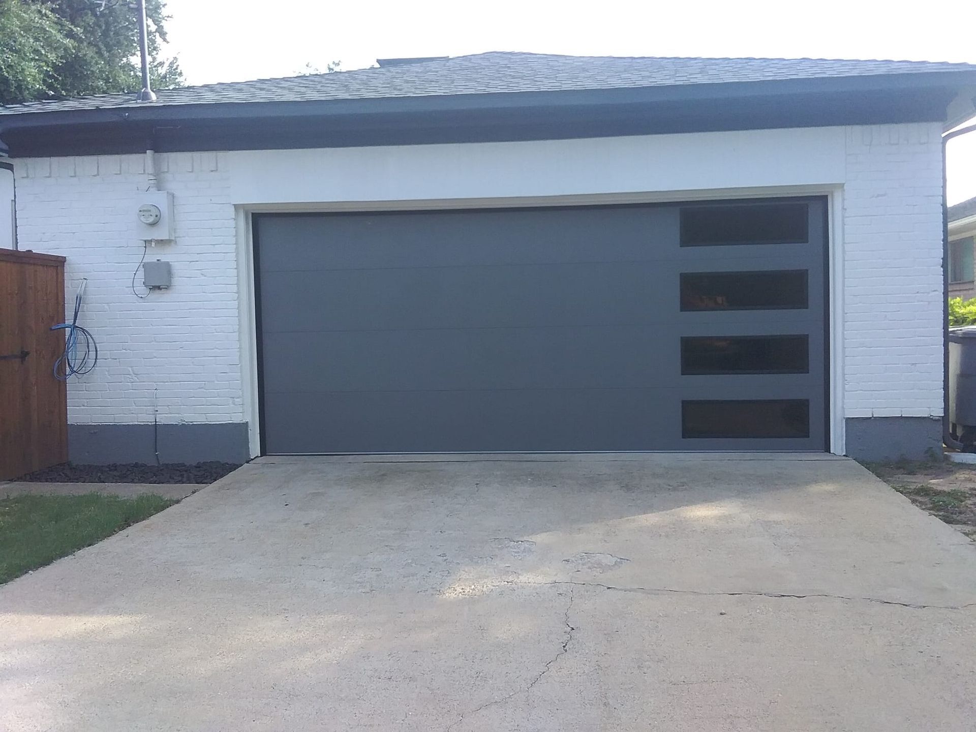 A white brick house with a gray garage door.