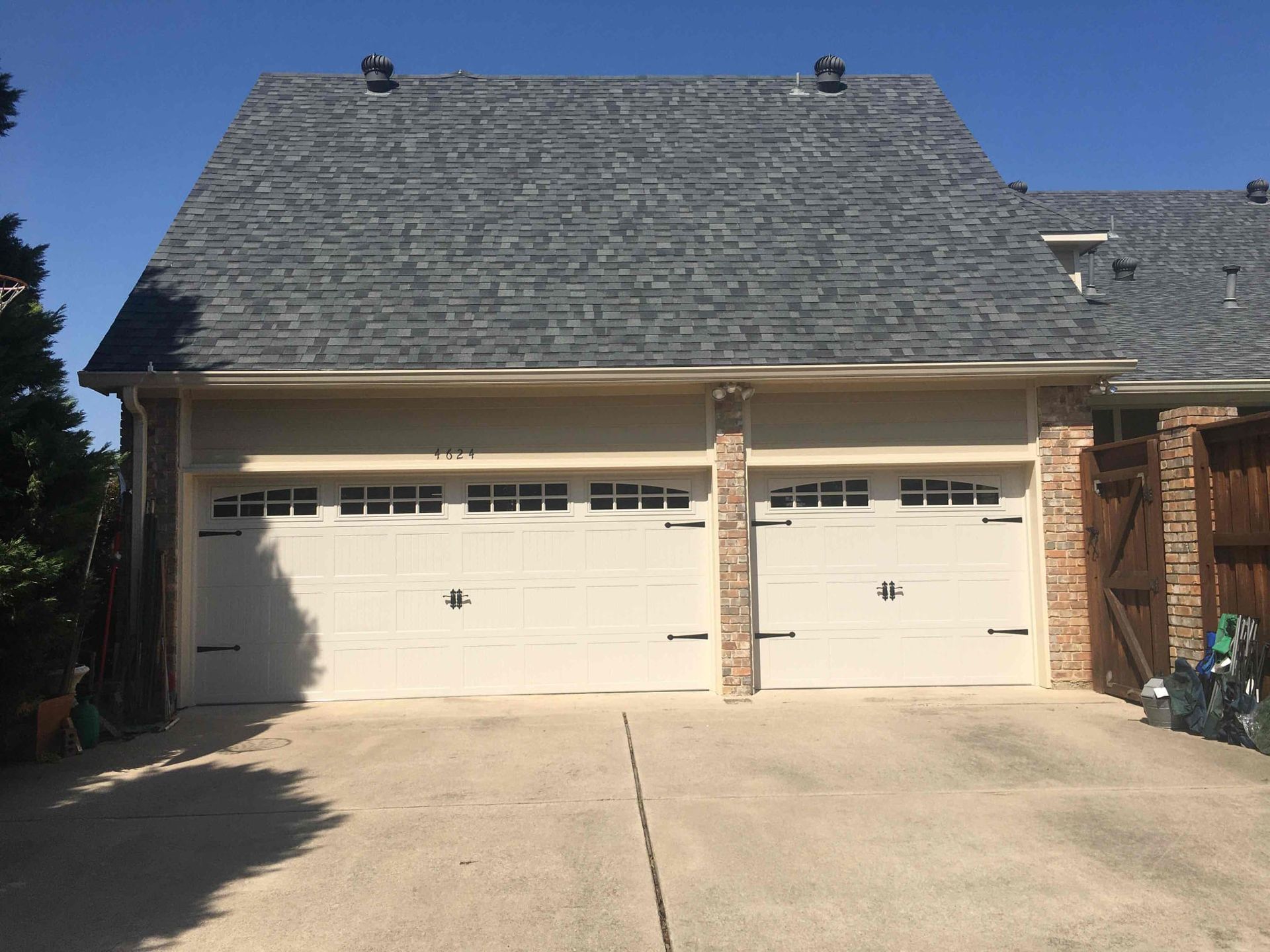 A garage with two white garage doors and a gray roof.