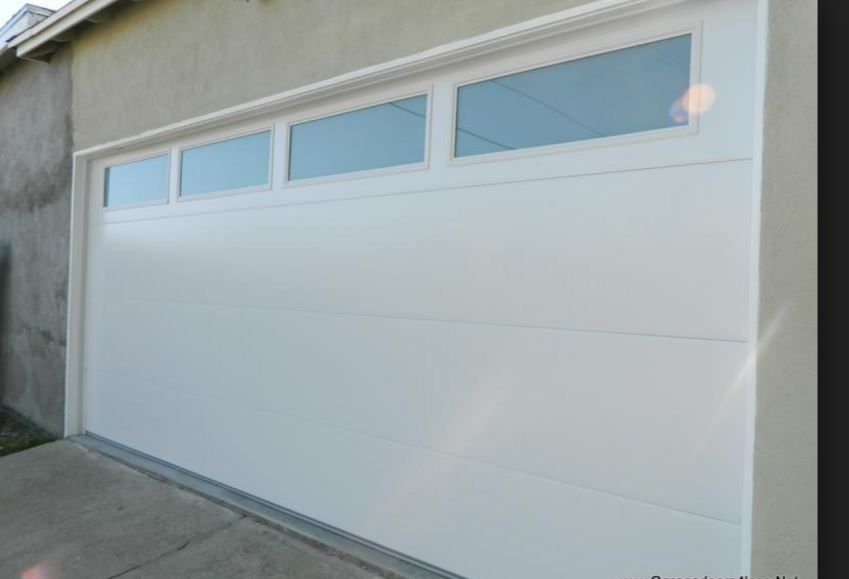 A white garage door with a lot of windows on it