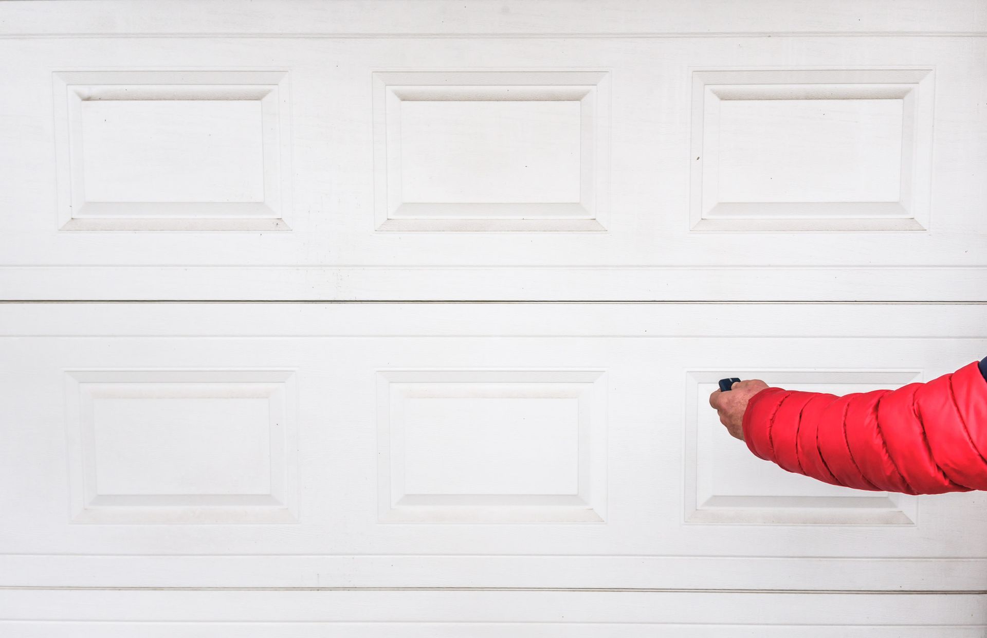 Hand operates the remote controller for easy access and reliable door function.