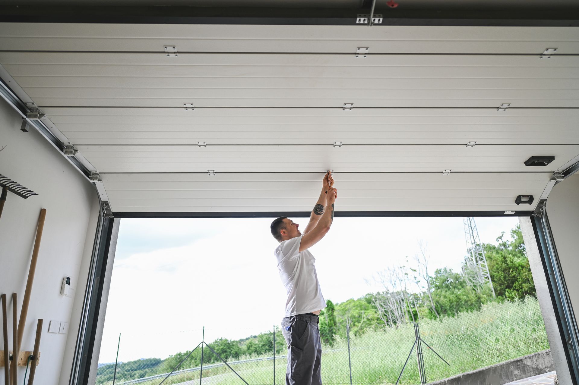 Garage door repair by Plano Overhead Garage Door in Coppell, TX, with a tech fixing a garage door 