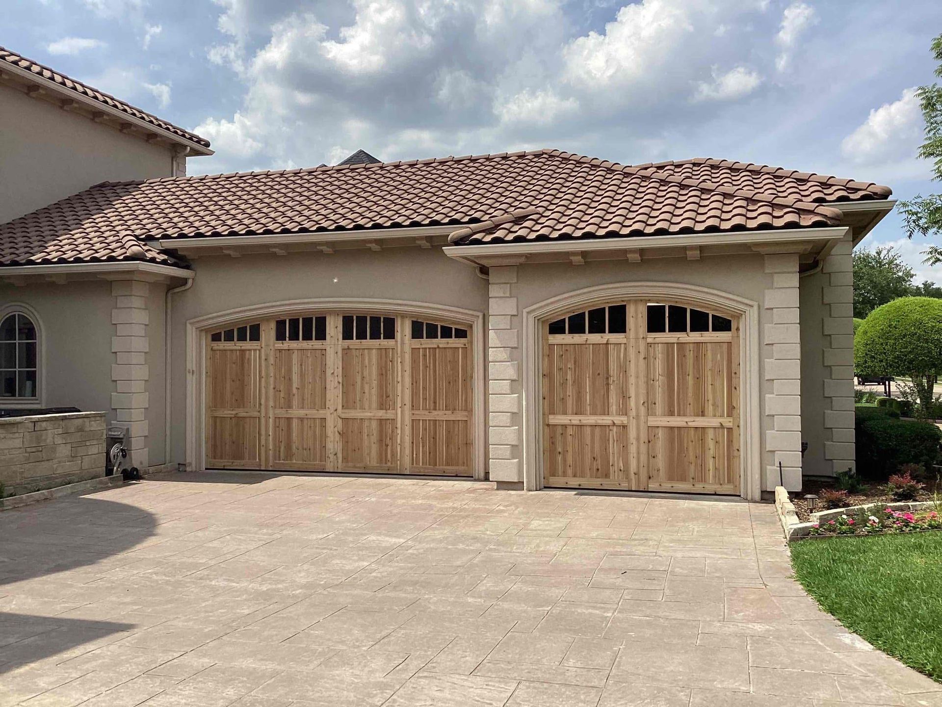 A large house with two wooden garage doors and a tile roof- Plano, TX 75074, USA- Plano Overhead Garage Door