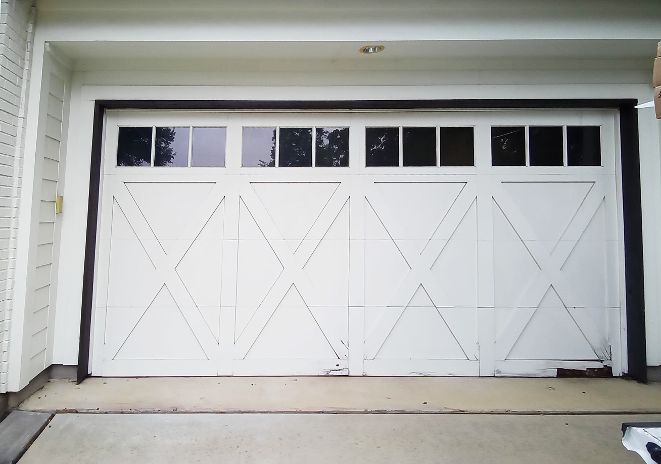White garage door with windows, diamond pattern, and black trim.