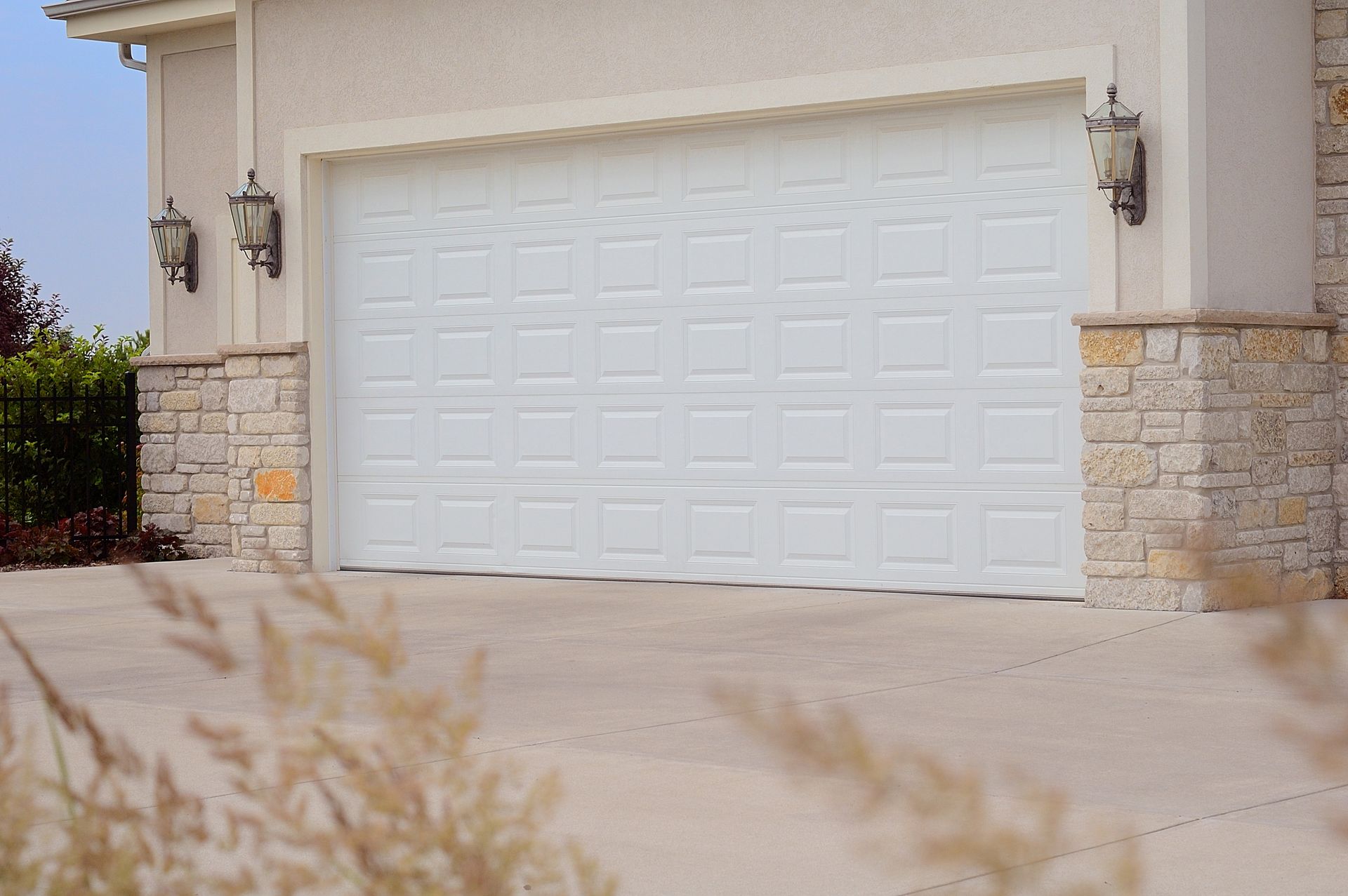 A white garage door is open in front of a house.