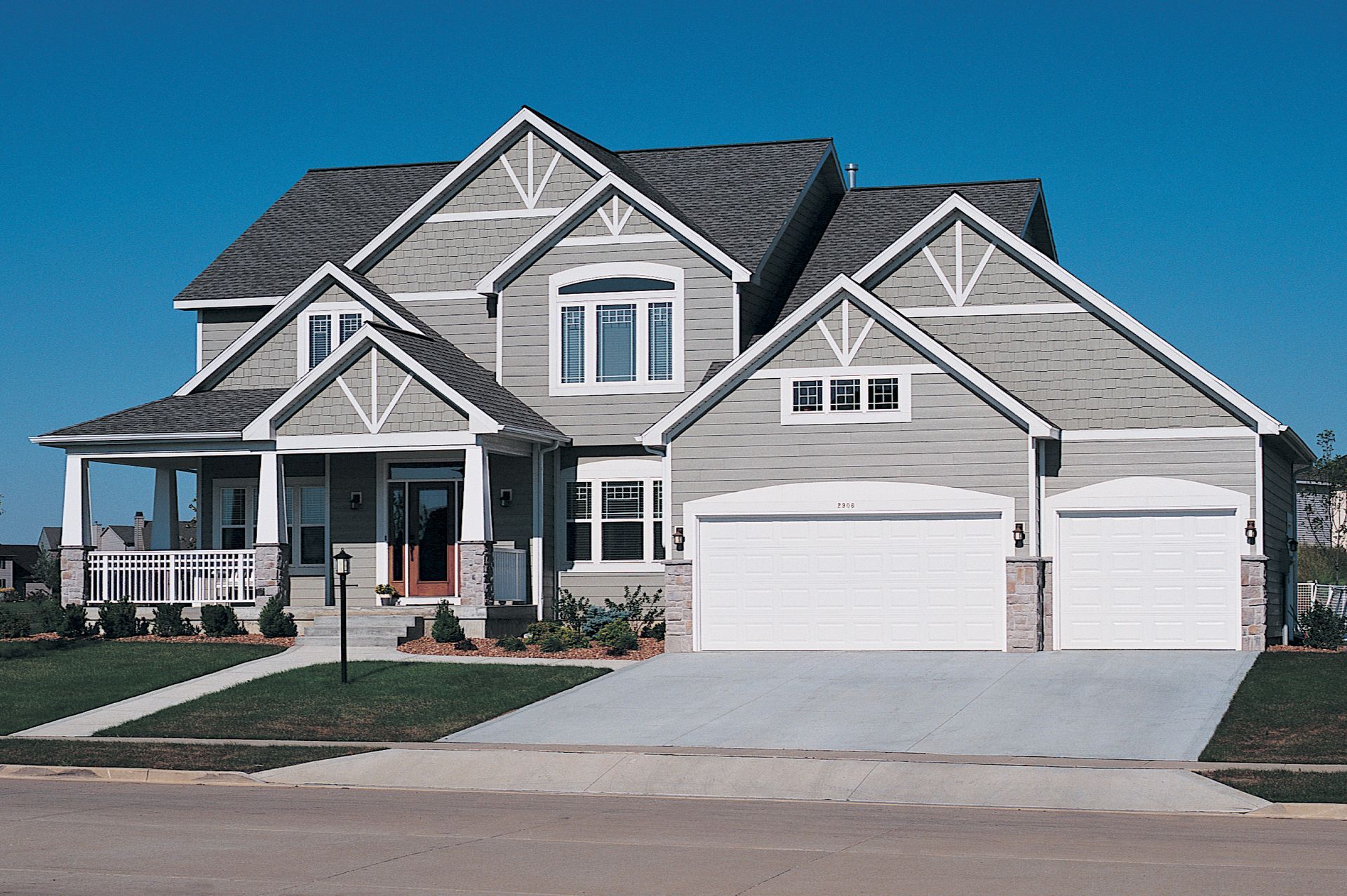 A large house with two garage doors and a porch