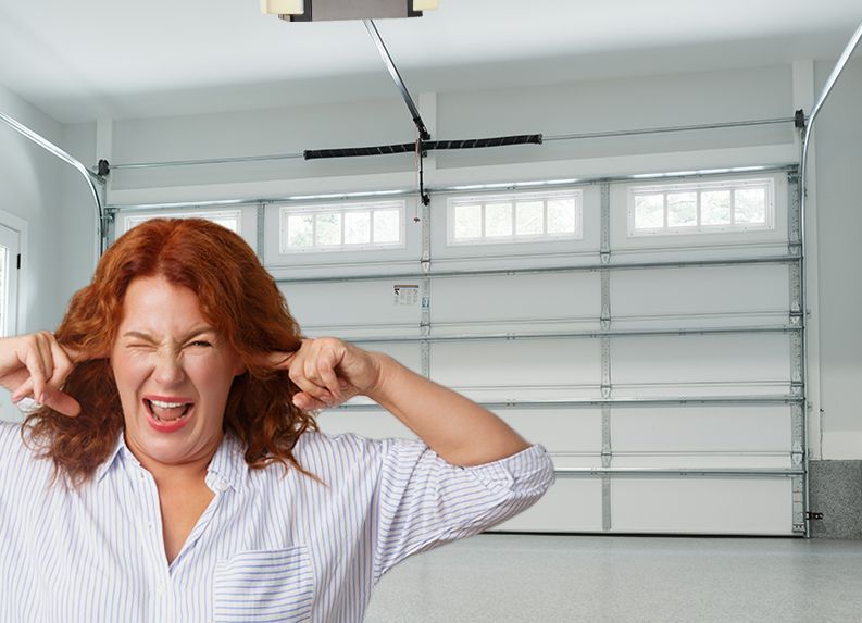 A woman is covering her ears because it has Noisy Garage Doors and Openers.